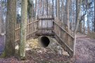 eingegrabene Betonröhre als Spielgerät im Wald