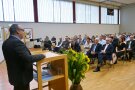 Michael Mayer am Rednerpult vor Personen im Raum
