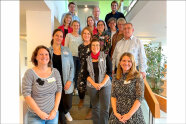 Gruppenbild der Coachingteilnehmer auf einer Treppe.