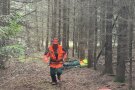 Mann im Wald läuft auf Kamera zu. Im Hintergrund liegt weitere Person.