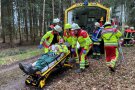 Rettungskräfte mit Mann auf Bahre vor Rettungs-Unimog