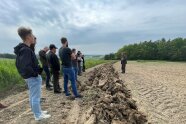 Gruppe steht auf Feld mit einer Beetle Bank.