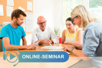 Zwei Männer und zwei Frauen sitzen um Tisch und schauen auf Blatt Papier mit Schriftzug Online-Seminar© Tobias Hase, StMELF